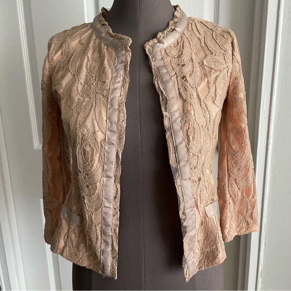 Quarter sleeve lace crewneck jacket with ribbon trim.